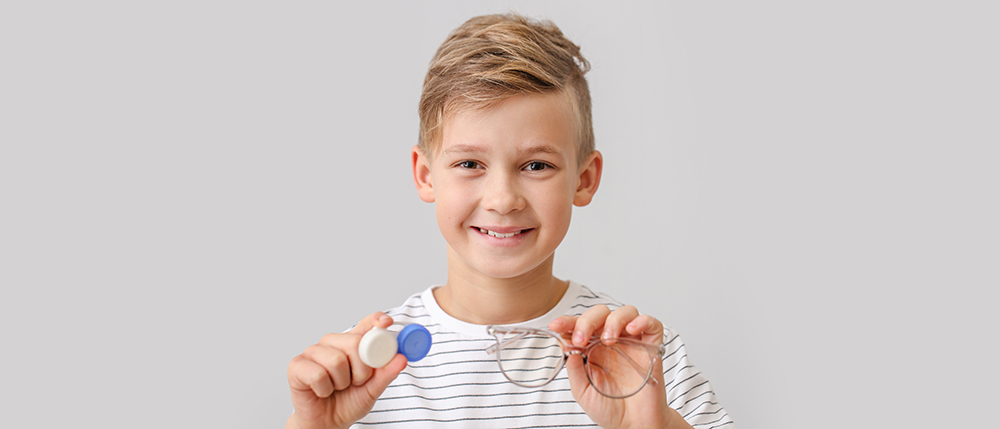 Boy holding contact lenses from Special Eyes Optical contact lens store in North Texas